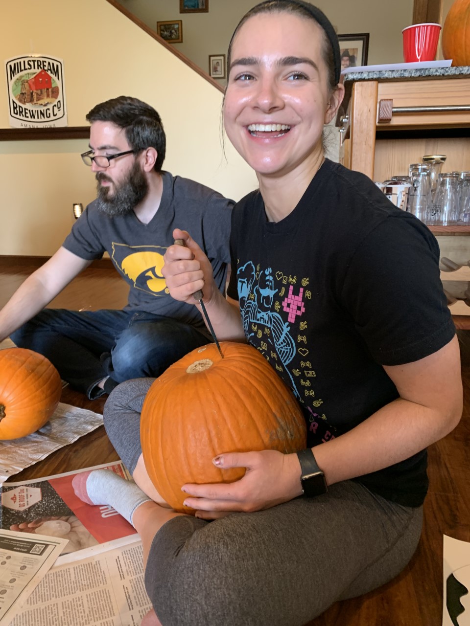 Leslie starting to carve her pumpkin from the bottom to place the candle in later