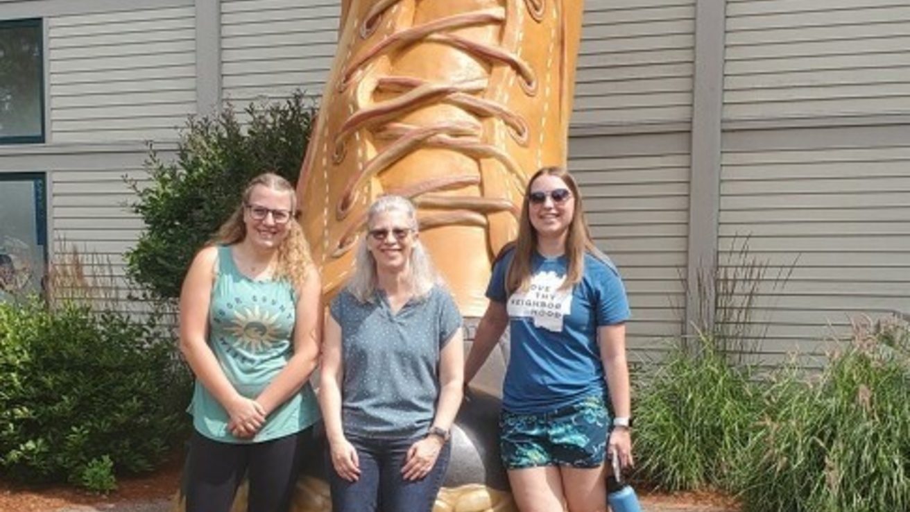 Hannah, Dr. Cole, and Andrea in front of the big boot